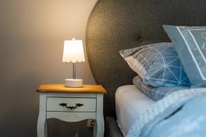 a nightstand with a lamp on it next to a bed at Lu Apartments in Oświęcim