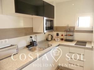 a kitchen with a sink and a counter top at APARTAMENTO VACACIONAL A 1 MINUTO DE LA PLAYA - CARIHUELA TORREMOLINOS in Torremolinos