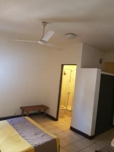 - une chambre avec un lit et un ventilateur de plafond dans l'établissement Hotel Le Relais Normand, à Antananarivo