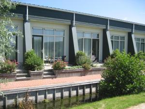 a building with windows and plants in front of it at Hotel Beemster in Middenbeemster