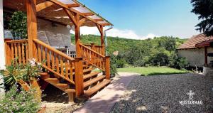 a wooden staircase leading to a house with a gazebo at Mustármag Vendégház in Noszvaj