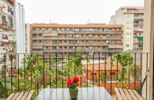 a table with a vase of flowers on a balcony at YOUR HOME - Sagrada Familia Apartment in Barcelona