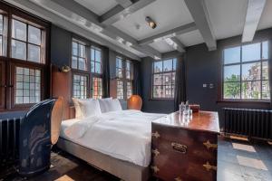 a bedroom with a large bed and windows at Boutique Hotel The Craftsmen in Amsterdam