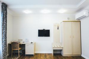 a room with a desk and a cabinet and a table at Business Hotel Vremena Goda in Moscow
