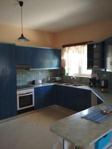 a kitchen with blue cabinets and a counter top at Villa Doxa in Ierápetra +13 photos