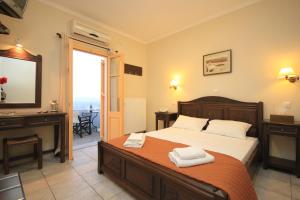 1 dormitorio con cama, escritorio y ventana en Maria's Place - Adults Only en Oia