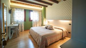 a bedroom with a bed and a desk and a window at Agriturismo Roccat in Valdobbiadene