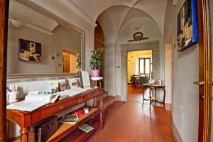Habitación con escritorio, espejo y pasillo. en Antica Locanda La Canonica, en Zocca