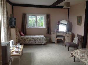 - une chambre avec un lit, une télévision et une table dans l'établissement Baron's Grange, à Iden