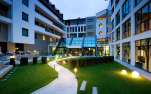 a courtyard in a building with a lawn and lights at Spa Hotel Persenk in Devin