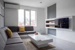 a living room with a couch and a tv at blueWave.place Sofia in Sofia