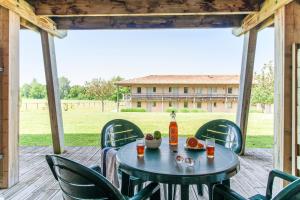 una mesa y sillas en un patio con un edificio en Résidence Pierre & Vacances Les Rives de la Seugne, en Jonzac