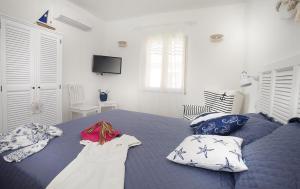 a bedroom with a blue bed with pillows at B&B Jolie in Santa Teresa Gallura