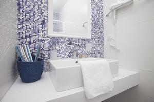 a white bathroom with a sink and a mirror at B&B Jolie in Santa Teresa Gallura +18 photos