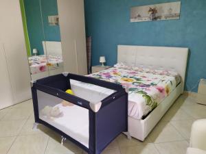 a bedroom with a bed with a crib and a mirror at Light Blue Room in Scordia