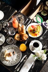 a table with plates of food and cups of coffee at Le Damantin Hôtel & Spa in Paris