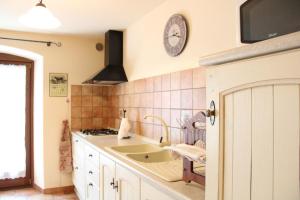 Una cocina con un fregadero y un reloj en la pared. en L'Atelier du Temps - Le Foyer du Cousin, en Nus 22 fotos más