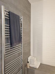 a bathroom with a shower with a towel and a pile of towels at Glanzvoller - Deine Auszeit in Markdorf