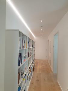 a hallway with white bookshelves and a white wall at Glanzvoller - Deine Auszeit in Markdorf
