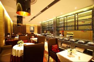 a dining room with tables and chairs and a restaurant at Yiwu Bai Heng Hotel in Yiwu