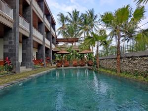 
a beach with a pool and a large building at Paon Desa Ubud in Ubud
