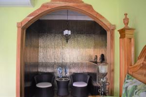 a room with a wall with an arch with two chairs at Haven View Villa & Spa in Bluefields +35 photos
