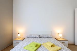 a bedroom with a bed with two yellow towels on it at PrimoPiano - Sammartini in Milan