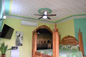 a bedroom with a bed with a ceiling fan at Haven View Villa & Spa in Bluefields
