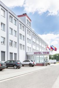 un hôtel avec des voitures garées devant lui dans l'établissement Hotel Trim, à Pardubice