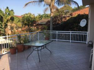 巴利托的住宿－84 Leonora Drive - Family Holiday Home，庭院设有桌子、围栏和棕榈树