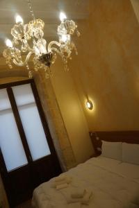 Un dormitorio con una lámpara de araña y una cama en PALAZZO FULGHER, en Cagliari