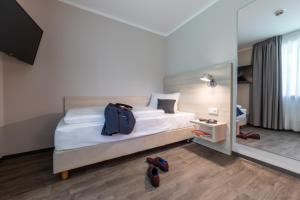 a hotel room with a bed with a backpack on it at Serways Hotel Waldmohr in Waldmohr
