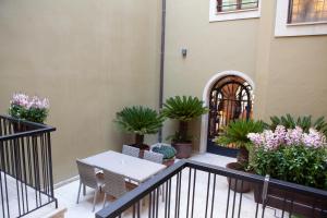 d'un balcon avec des plantes, une table et des chaises. dans l'établissement Palacete Colonial, à León