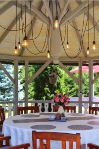 a dining area with a table and chairs and lights at Marie Chalet in Breaza