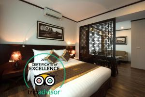 a bedroom with a bed with a sign that reads certificate of excellence at Thang Long Opera Hotel in Hanoi