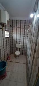 ein Bad mit einem WC und einer Wand in der Unterkunft Hotel Prakash in Rāmeswaram