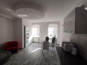 a white living room with a table and chairs at Apartament wygodny S4 in Kalisz