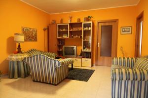 uma sala de estar com duas cadeiras e uma televisão em B&B La Villetta em Benevento