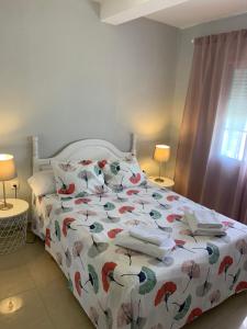 1 dormitorio con 1 cama con colcha de flores en Apartamento CENTRO, en Mazagón