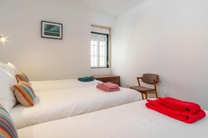 een slaapkamer met 2 bedden en een stoel bij LV Premier Bica in Lissabon