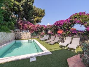 - une piscine avec des chaises et des fleurs dans la cour dans l'établissement Villa with private pool and sublime views, à Èze