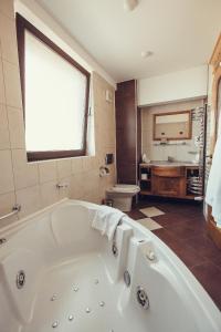 a large bathroom with a tub and a sink at Denisa Boutique in Poiana Brasov