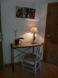 een bureau met een lamp en een stoel naast een deur bij Route de Nieul in Le Girouard