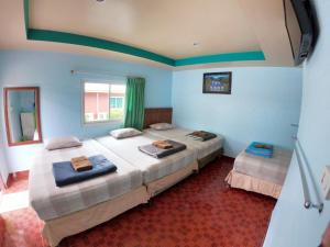 Duas camas num quarto com paredes azuis em Somjainuk Resort 2 em Pluak Daeng