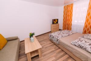 1 dormitorio pequeño con 2 camas y sofá en Apart-hotel on Kondrateva street New Building, en Sumy