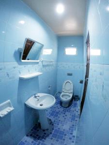 uma casa de banho azul com um WC e um lavatório em Somjainuk Resort 2 em Pluak Daeng