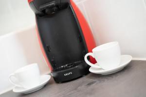 two white cups and saucers sitting on a counter at Greyfriars Flat in Perth