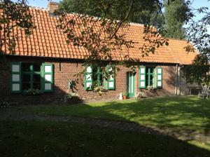 Casa de ladrillo con ventanas verdes y patio en Ma Campagne, en Heusden
