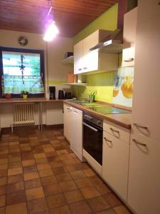 een keuken met witte kasten en een televisie. bij Ferienwohnung im Rottal in Oberrot