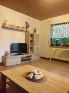 a living room with a table and a tv at Ferienwohnung im Rottal in Oberrot